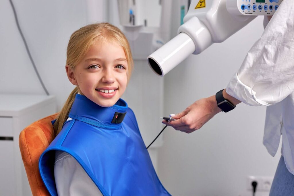 Child at dental clinic with digital X-ray for better dental care.