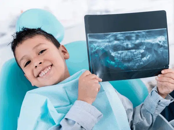Child holding a dental image showing what is digital X-ray