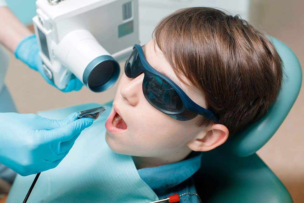 Child getting a dental digital X-ray at a clinic.