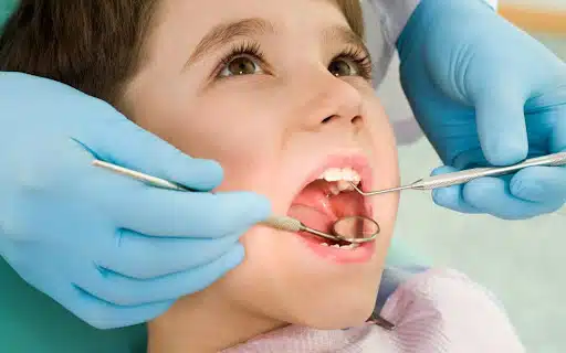 Child sitting in dental chair ready for dental filling material procedure