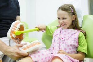 child-practicing-brushing-teeth-model