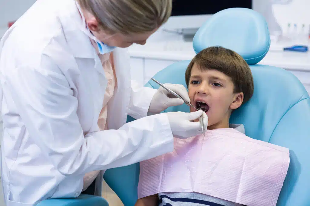 Young boy sitting comfortably in a modern dental examination chair.