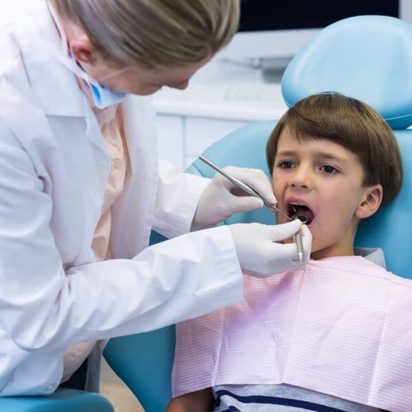Young boy sitting comfortably in a modern dental examination chair.
